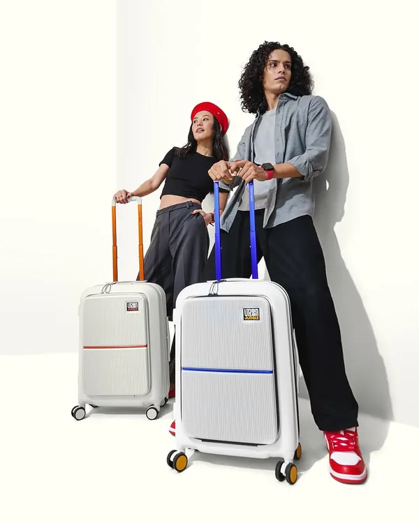 A cool and edgy campaign shot for a travel gear brand. The makeup for both models is minimal and fresh, reflecting a modern, urban style that is effortlessly chic and ready for an adventure.