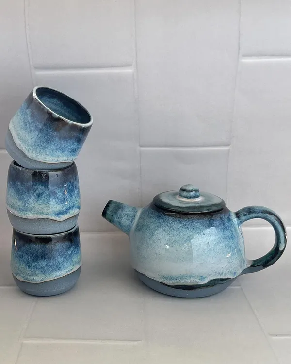 My light blue teapot and cup set, arranged to show the beautiful, frosty glaze. This wheel-thrown set is perfect for a peaceful afternoon tea.
