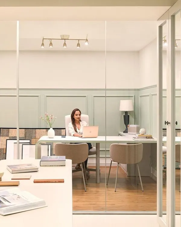 A view into my personal cabin at the Furbishy HQ. The space is designed with glass walls to maintain a sense of openness, while the soft green wall paneling and clean, modern desk create a calm and inspiring work environment.