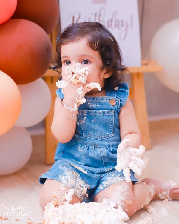 Getting every last bit of frosting! This close-up captures the pure delight of a baby's first cake smash. It's a memory full of sweetness and fun.