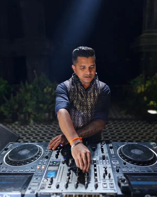 A close-up shot of me at the console during a night event. The focus is intense as I line up the next track to keep the energy flowing seamlessly.