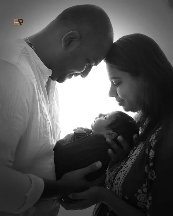 This is the heart of what we do: capturing the profound, quiet love that fills the room when a new family is born. This black and white portrait focuses purely on the connection between parents and their newborn, creating a timeless and powerful memory.
