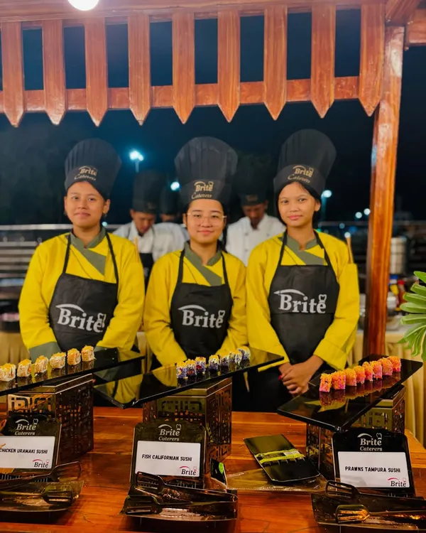 My team of sushi chefs, professionally dressed and ready to serve a variety of freshly made sushi rolls at the Japanese counter.