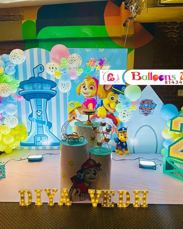 A fun-filled Paw Patrol themed birthday party for two siblings. The setup includes a large backdrop with the iconic lookout tower, character cutouts of Chase and Skye, themed plinths, and marquee numbers for each child's age.