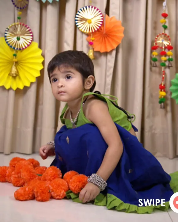 The Nila Ghagra Choli is a favorite for its vibrant colors. The combination of a parrot green choli and a royal blue skirt with a ruffled hem is designed to make your little girl feel special and ready to celebrate.