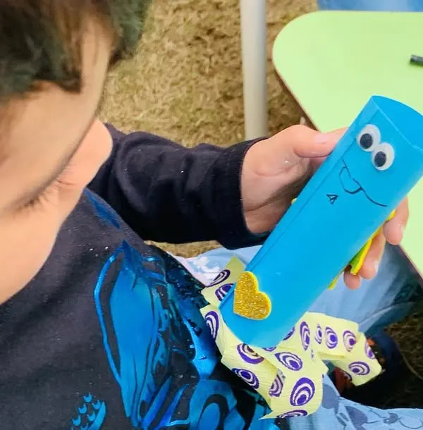 A child proudly shows off the googly-eyed craft he made during our launch day event. I believe in providing activities that are not only fun but also give kids a sense of accomplishment.