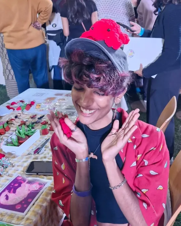 This is me, Lex, at an art market, overjoyed with the support from everyone. I'm wearing a crochet octopus on my hat, because why not?
