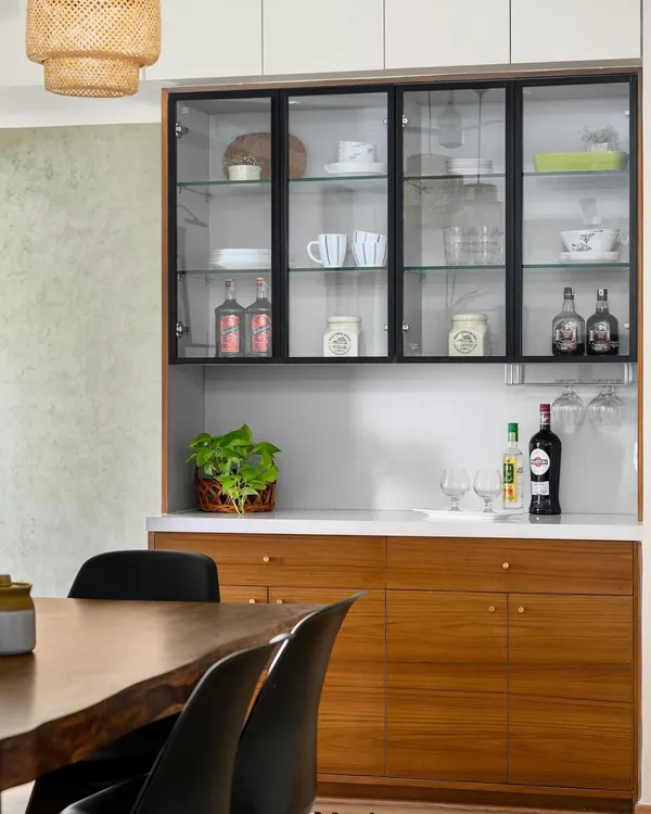 This crockery-cum-bar unit from our 'Wind-chime' project features black-framed glass shutters and a solid wood base, providing a sophisticated spot for dining storage and entertainment.