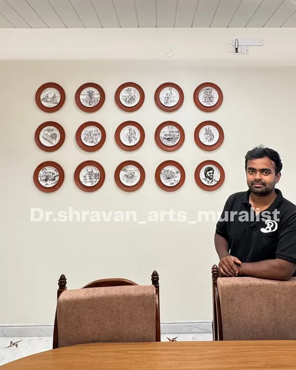 Here I am with a completed wall installation of 15 custom-painted porcelain plates. This collection tells a story, with each plate featuring a unique sketch, from Rajinikanth to Jallikattu.
