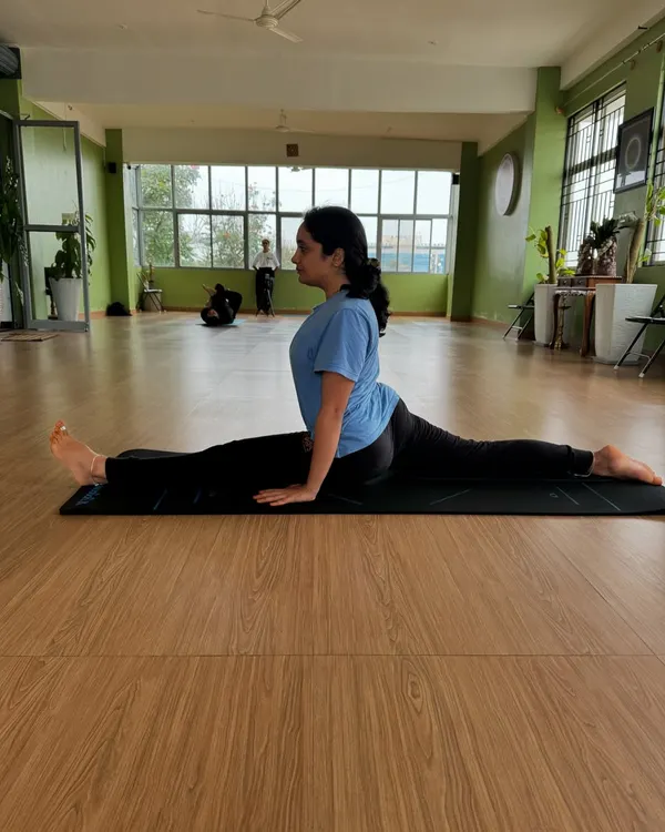 A student demonstrating Hanumanasana (Front Split). This posture requires patience and consistent practice, and we guide our students to open their hips safely over time.