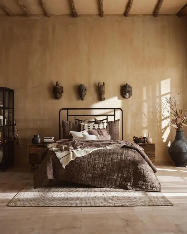 An earthy, wabi-sabi inspired bedroom scene. We used natural light and a palette of warm browns and textured linens to create a tranquil and grounded atmosphere, highlighting the rustic furniture and decor.