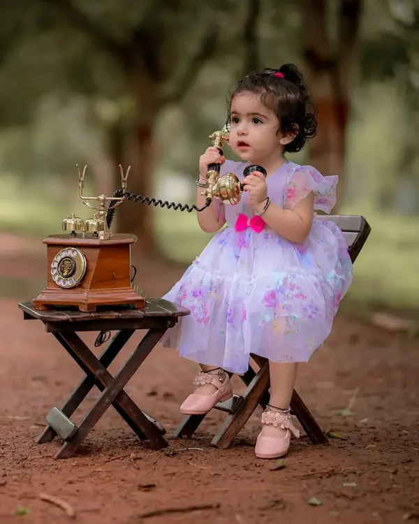 I love creating these whimsical scenes. Here, little Naira is having a very important conversation on a vintage rotary phone during her themed portrait session. It is these playful, imaginative moments that make for unforgettable baby photography.