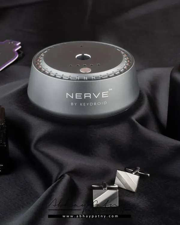 A moody and luxurious shot for a range of car fragrances. The dark, silky fabric and elegant props like cufflinks create a sophisticated atmosphere that aligns with a premium automotive brand.