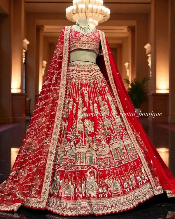 This is a quintessential bridal masterpiece. A stunning red lehenga featuring intricate embroidery of royal processions and architectural motifs, designed to make you feel like royalty on your wedding day.