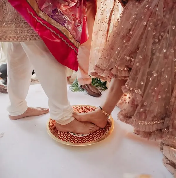 A close-up of a traditional wedding ritual being performed on the sandy shores. We focus on capturing these meaningful details that are central to the wedding ceremony.