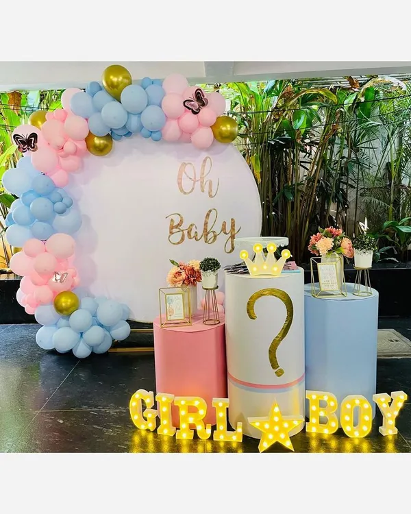 A complete 'Oh Baby' shower setup featuring my signature circular backdrop with custom gold lettering, a modern pastel balloon garland, and fun marquee lights for a gender reveal.