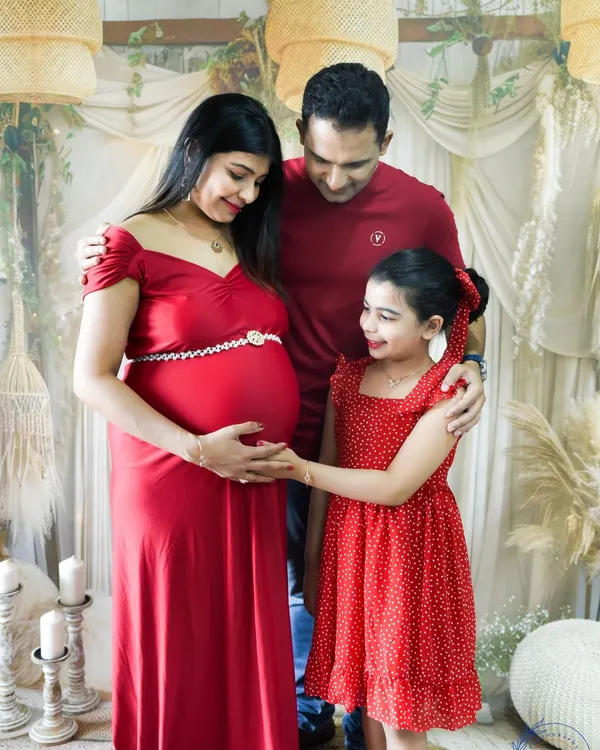 Including the whole family is so important. This beautiful family portrait shows the older sister-to-be gently touching her mom's baby bump in our cozy studio.