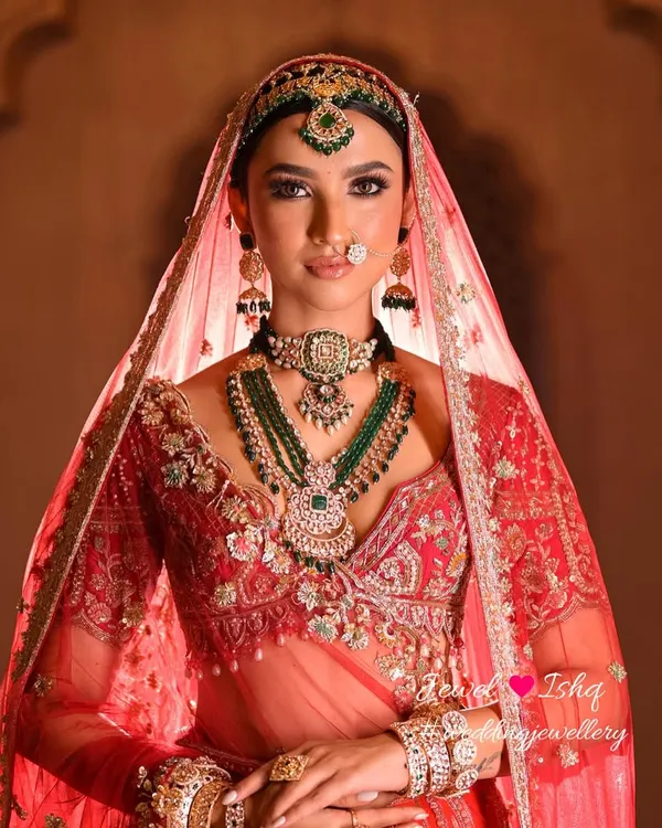 This is the ultimate royal bride moment. I styled this complete look with a layered Kundan and emerald necklace set, a matching sheeshpatti headpiece, and a delicate nath. It's all about creating that breathtaking, timeless elegance for your main wedding ceremony.