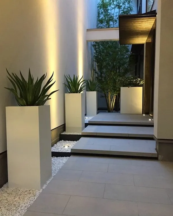 For a clean and formal entrance, I used these tall, white FRP planters. Their minimalist design and architectural shape add a sense of modern sophistication to the space.