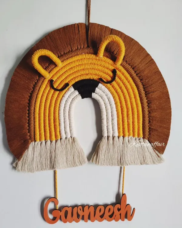 This macrame lion face, made for a little one named Gawneesh, is one of my favorite designs for a kid's room. The mix of mustard, brown, and white cotton cords creates a friendly and playful character. I can add any name to make it a truly special and personal gift.