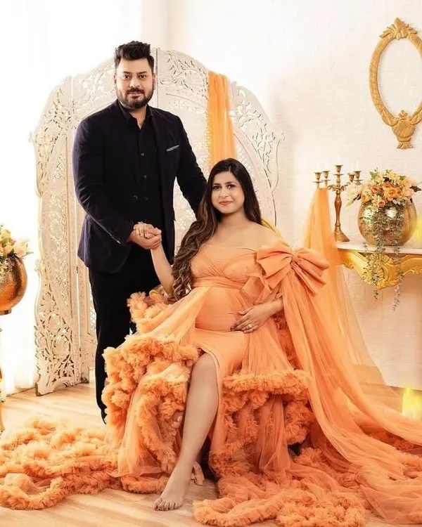 This peach gown with a large bow and a full ruffled train is the definition of glamour. It's perfect for a luxurious indoor photoshoot, creating a regal and celebratory feel.