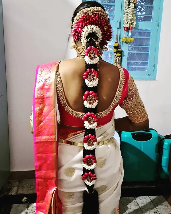 A stunning example of a traditional Poola Jada, or floral braid. This intricate design uses fresh flowers and is a classic choice for South Indian brides.