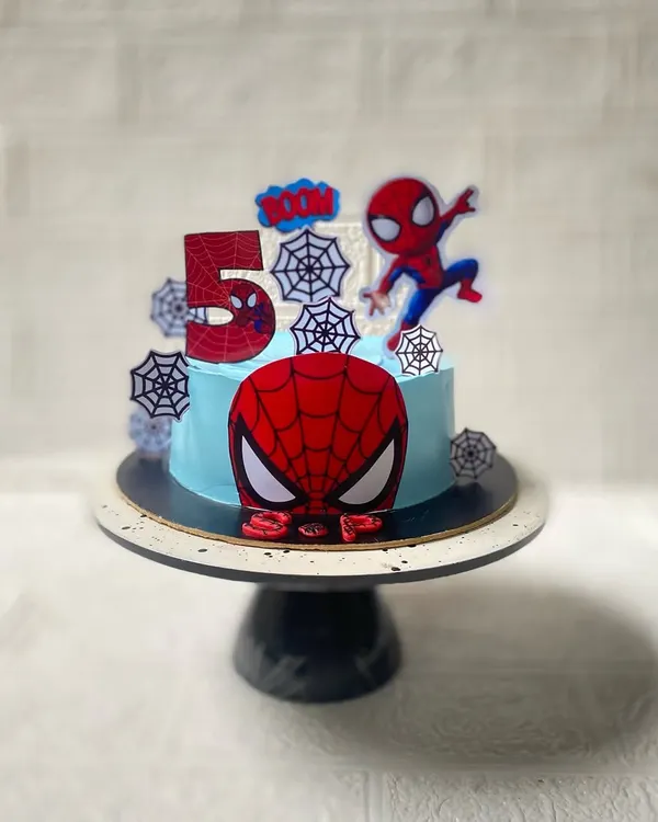 Your friendly neighbourhood Spiderman, ready for a 5th birthday party. This chocolate cake features a sky-blue frosting, spider webs, and our hero in action.