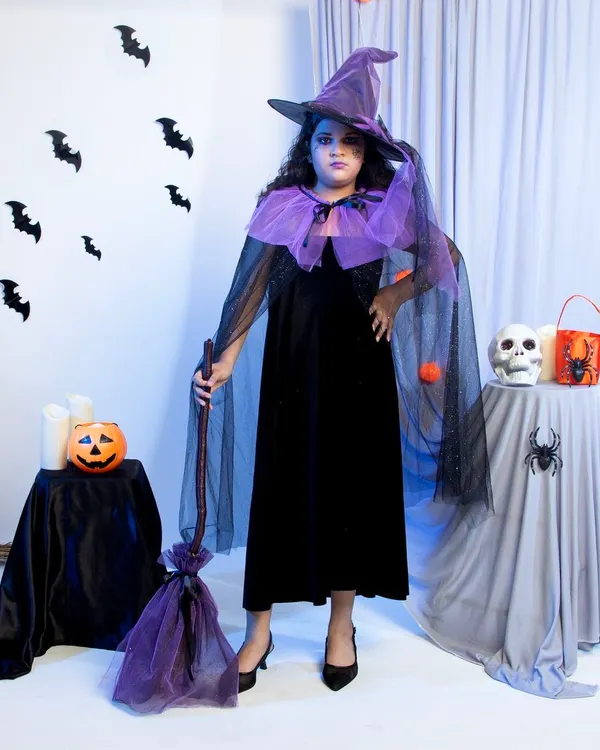 A full-length shot of a child's witch costume, captured against a custom-built Halloween set in the studio. This type of image is perfect for a main product listing on Amazon or Flipkart, as it shows the entire costume, accessories, and overall theme at a glance.