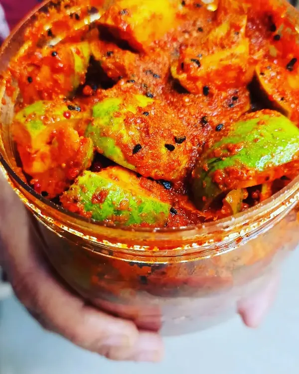 A close-up look at my classic Punjabi mango pickle, bursting with tangy flavour. Each piece is coated in my special blend of hand-roasted masalas and pure kacchi ghani oil, giving you that perfect 'ghar ka swad'.