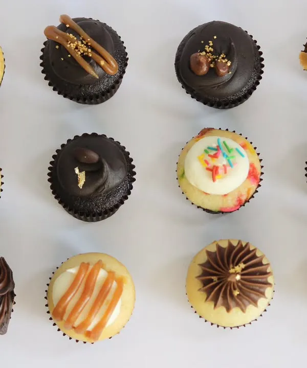 An overhead shot displaying the full variety of TBC Minis you can find in an assorted box. Each one is decorated differently to reflect its unique flavour, from rich chocolate to Indian-inspired Kesar Pista.