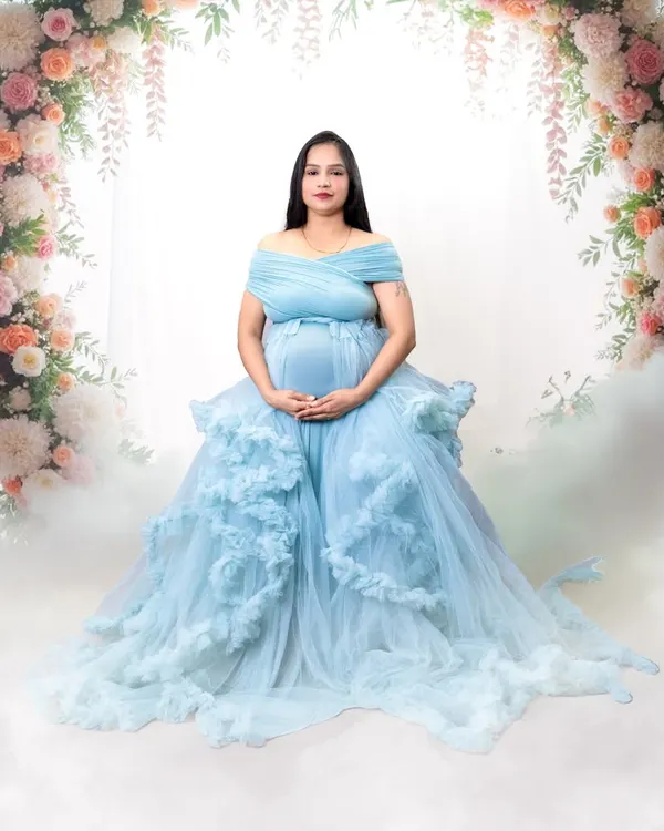 A breathtaking portrait in a ruffled, sky-blue gown. The floral arch and dreamy smoke effect create a fairytale scene right in the studio.