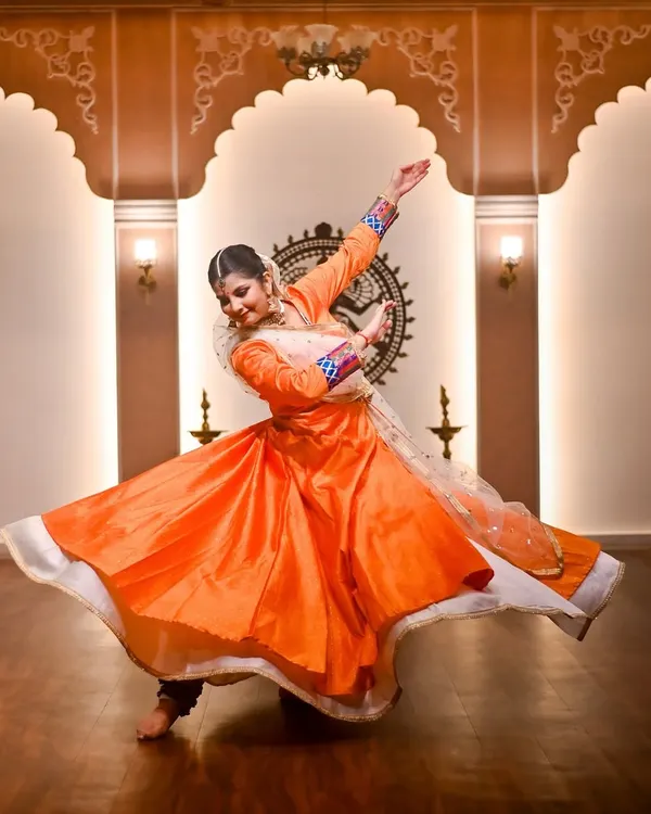 A moment of pure energy during a solo performance. This dynamic spin, known as a 'chakkar', is a hallmark of Kathak, captured here in a traditional costume against the backdrop of a Nataraja, the lord of dance. This is the essence of my sadhana.