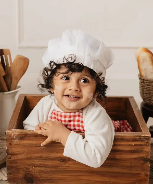 This little baker is having a blast in his own mini-bakery. Themed sessions like this are a wonderful way to capture your child's playful spirit.