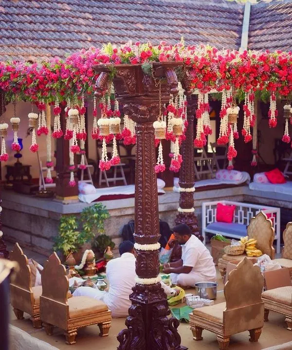 I love bringing a traditional mandap to life in a heritage setting. Here, at a 240-year-old Thottimane, we used antique wooden pillars, bougainvillea, and hanging floral strings to create a sacred and beautiful space.