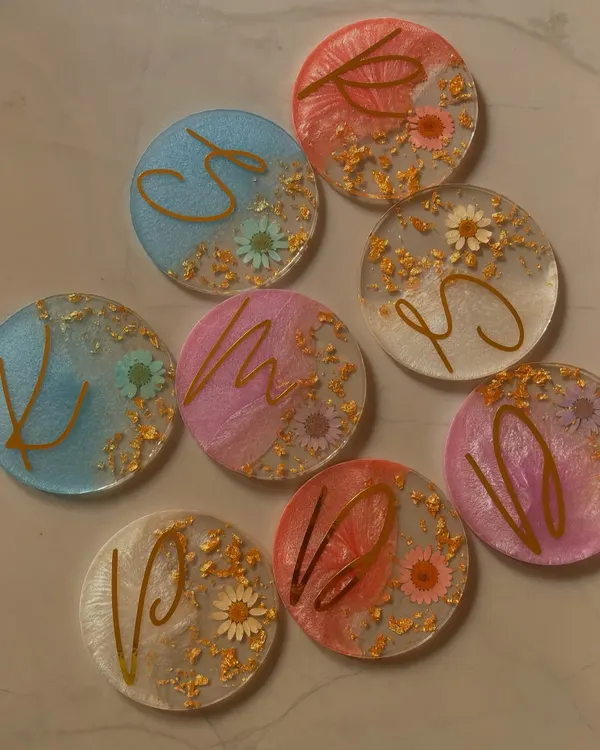 My handmade resin initial coasters. Each one is a small piece of art, combining shimmer, dried flowers, and gold leaf to create a beautiful and functional personalized gift.