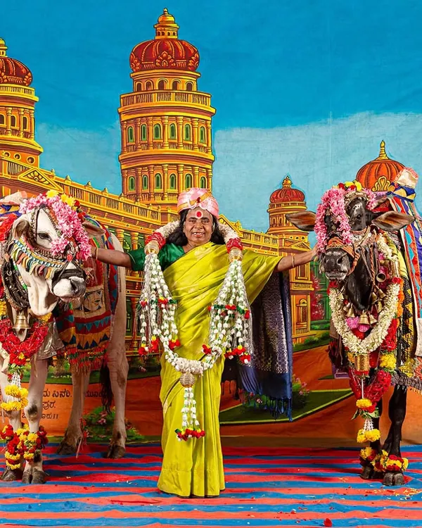 A vibrant photo-performance from my solo show 'No Longer A Memory'. Here, I stand with my mother and two decorated bulls against a theatrical backdrop, a scene that blends rural memory with a pop-art sensibility.