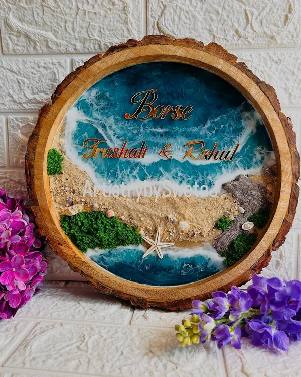 Bringing the beach to your doorstep. This personalized ocean-themed nameplate is set in a natural wood slice and features real sand, seashells, and beautiful resin waves.