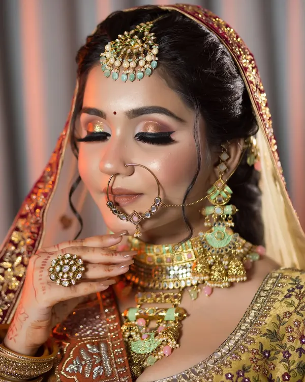A close-up of a golden-bronze cut-crease eye makeup. The shimmer catches the light beautifully, making the eyes look bright and captivating. This is perfect for an evening reception.