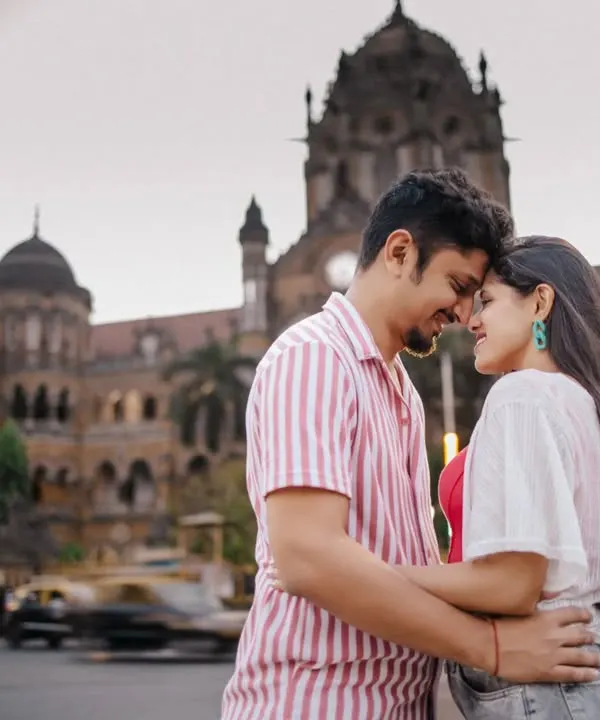 A romantic close-up in front of Mumbai's CST station, with the motion of traffic blurring around you. This technique creates a powerful image of finding stillness and connection in a fast-paced city.