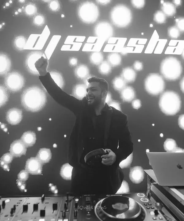 A moment of pure joy behind the decks. This black and white shot captures me in my element, with my logo lighting up the background. It's more than just playing music; it's about creating an unforgettable night.