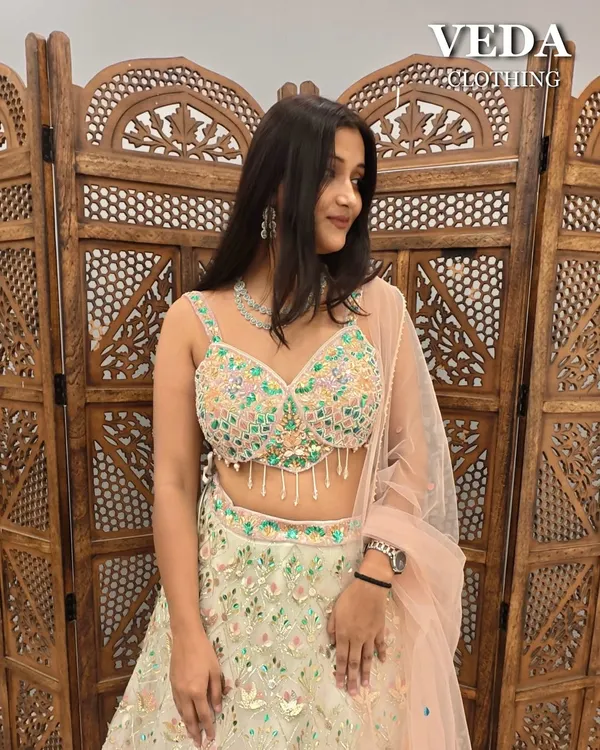 This light green lehenga with multi-color floral embroidery and a peach dupatta is a fresh and fun choice for a Mehendi.