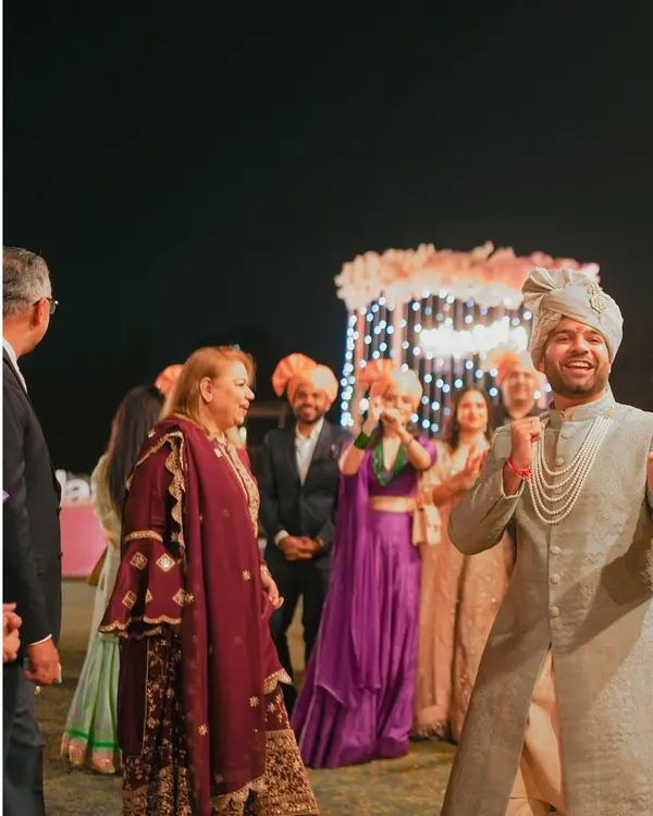 The groom's infectious energy during the Baraat. This shot captures the pure joy and excitement of the groom's procession.