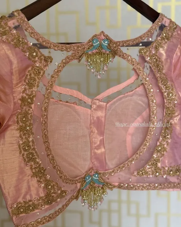 A beautiful example of a sheer back blouse with a large circular cutout. The design is embellished with bird motifs and delicate tassels, creating a look that is both elegant and playful.