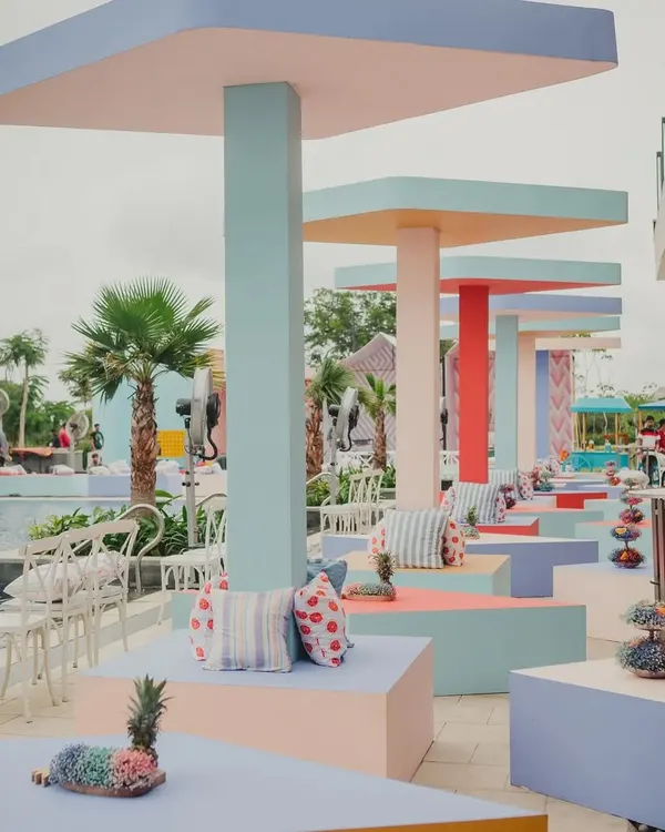 A poolside brunch with a modern twist. We designed and built these rhombus-shaped canopies and triangular seating blocks in a palette of fresh, happy pastels, creating a fun and geometric landscape.