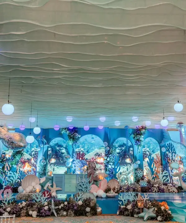This is what it looks like to step into a dream. For this 'Under the Sea' first birthday, I designed an immersive underwater wonderland, using layered backdrops, custom props, and ethereal lighting to create a truly magical experience for our little mermaid and her guests.