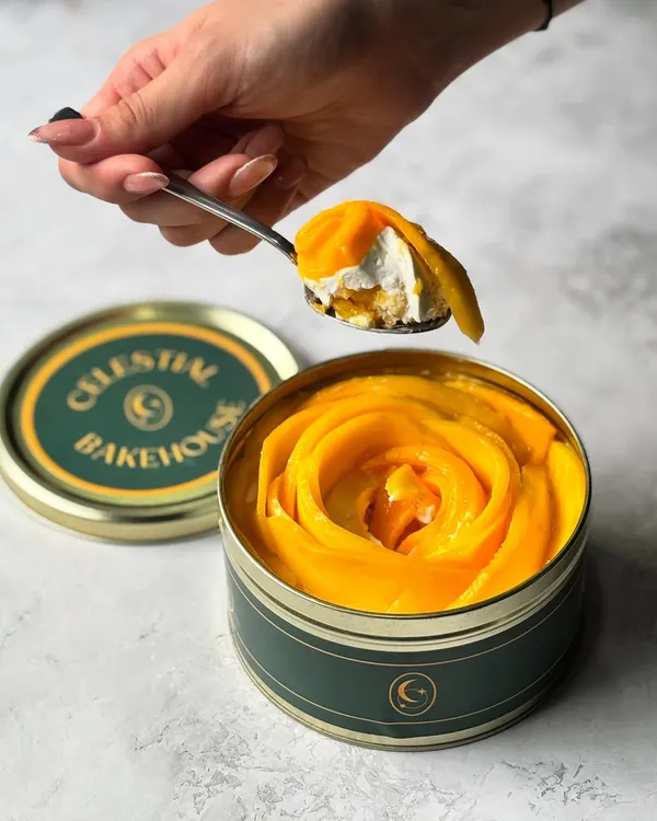A perfect spoonful of our Mango Tres Leches. You can see the layers of light sponge, creamy filling, and fresh mango in every bite.