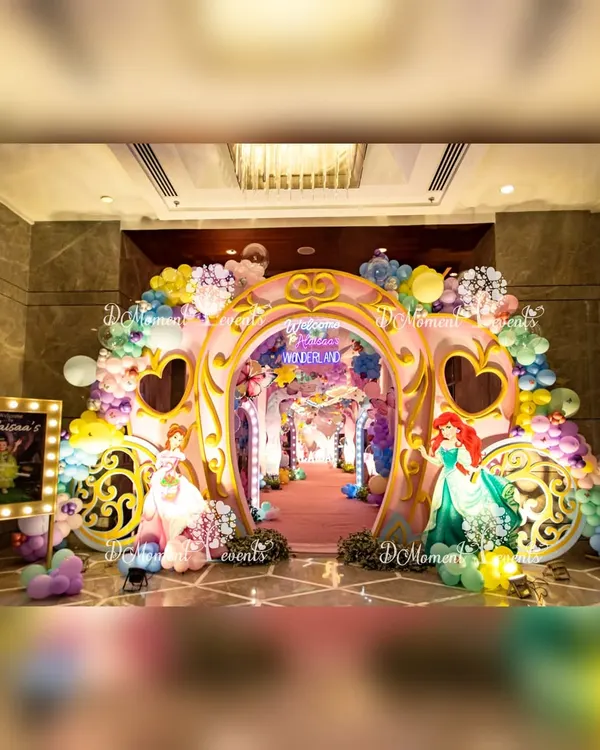 A magnificent princess carriage archway makes for a grand entrance, welcoming guests to a wonderland of pastel balloons and beloved princess characters.