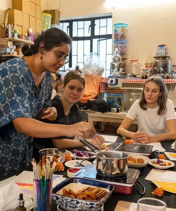 Our instructor, Sudha, demonstrates the process of extracting pigment during a botanical ink workshop. Participants gather around to learn how to turn simple, natural ingredients into a palette of beautiful, earthy colors.