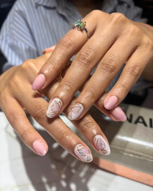 A delicate and feminine design featuring a soft pink base with intricate butterfly wing art. The gold detailing adds a touch of sparkle, creating a look that is both subtle and enchanting.