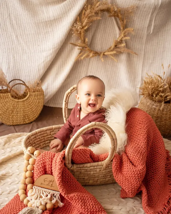 Look at that happy smile. Sitter sessions, for babies who can sit up on their own, are full of personality. I use simple, rustic props like this wicker basket to keep the focus on your baby's expressions.